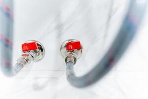 This detailed closeup image showcases a hose featuring two bright red valves, distinctly emphasizing their unique design and essential functionality within the overall equipment setup photo