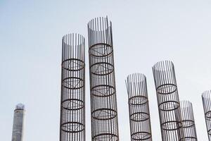 A long row of shiny metal pipes stands out vividly against a clear blue sky, showcasing the industrial beauty and functionality of these cylindrical structures made of various metals photo
