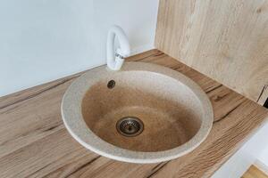 A beautifully crafted round sink is elegantly positioned atop a beautifully polished wooden counter, showcasing a perfect blend of style, sophistication, and functionality for any space photo