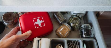 An Efficiently Arranged Kitchen Drawer Equipped with a First Aid Kit and Various Jars Filled with Spices for Cooking and Culinary Use Enhance Condiments and Wellness photo