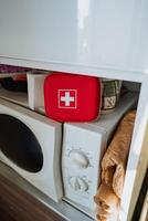 This Compact First Aid Kit is designed for convenient storage right beside your Microwave in a sleek, modern kitchen setting, ensuring easy access to your healthcare needs photo
