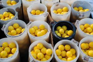 An array of plastic cups in various colors, each overflowing with bright yellow balls, forms a lively and cheerful display that attracts the eye and effectively draws attention to itself photo