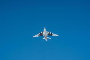 A bright white airplane is soaring gracefully through a beautifully clear blue sky on a lovely, sunny day, showcasing the wonders of aviation and air travel. Its a magnificent sight photo