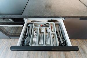 A kitchen drawer that is completely filled with an assortment of silverware and various utensils, showcasing organization and convenience in cooking and meal preparation photo