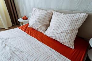 In a beautifully decorated bedroom, there is a cozy bed adorned with striped sheets and soft pillows, creating a welcoming and comfortable atmosphere for rest and relaxation photo