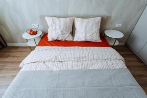 In a cozy bedroom, a comfortable bed with a velvety red comforter and soft white pillows creates an inviting atmosphere for rest and relaxation, making it an enchanting sanctuary photo