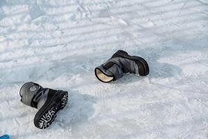 Abandoned Winter Boots Left on the Snowy Ground are a Strong Representation of Adventure and the Activities Associated with Cold Weather Usages Such as Skiing or Hiking photo