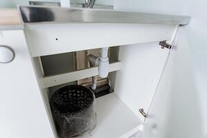 In a kitchen, there is a sink positioned conveniently underneath a cabinet, serving as a practical plumbing fixture that contributes to the overall design and functionality of the space photo