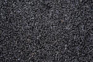 This is a closeup view of black rubber granules, which are ideal for use in sports flooring and playground surfaces. They ensure both safety and durability for users photo