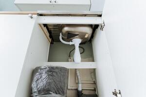 A properly installed kitchen sink positioned beneath a cabinet is crucial for ensuring optimal functionality and convenience in the oftenused kitchen area where daily tasks are performed photo