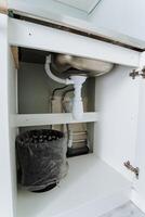 If you check under the sink cabinet, you will discover a conveniently placed trash can that allows for easy access and efficient waste disposal whenever you need it, ensuring cleanliness photo