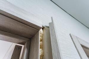 This image features a detailed closeup view of a door, clearly showing foam seeping out of the edges, which suggests that there may be some underlying issue or damage present photo