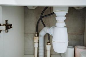 In a typical bathroom environment, you can find a sink that has a drain pipe placed directly underneath it, enabling the effective and proper disposal of wastewater following usage photo