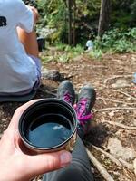An individual is holding a cup filled with crystalclear water, emphasizing the essential role and significance of this everyday item that is commonly used for hydration purposes photo