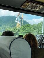 A man and a woman are seated on a public bus, both gazing out the window, perhaps lost in their thoughts or enjoying the scenery passing by. They appear to be passengers on a journey photo