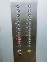 This image features a closeup view of a stainless steel elevator control panel, showcasing its modern design and technological features, emphasizing its sleek and shiny silver finish photo