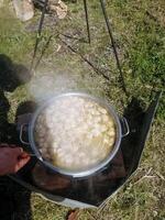 A person is actively stirring a pot of delicious soup using a wooden spoon, enhancing the flavors as it simmers. This process is essential for creating an enjoyable meal photo