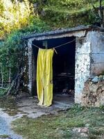 A vibrant yellow cloth is currently hanging out on a clothes line in an outdoor setting adjacent to a building, where it catches the eye with its bright color and uniqueness photo