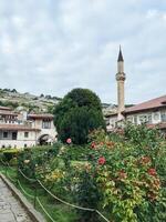 In the center of a beautiful garden, there stands a mosque complete with an impressive tower that majestically rises into the sky, offering a serene and peaceful atmosphere photo