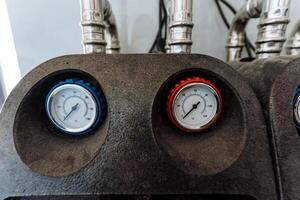 Here is a detailed closeup view featuring two pressure gauges that are mounted on a machine, serving as essential measuring instruments to monitor pressure levels precisely photo