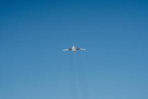 A plane is soaring gracefully and majestically through a vast and clear blue sky, taking full advantage of the beautiful and wonderful weather on this delightful sunny day photo
