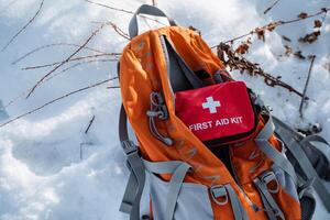 A reliable backpack with a stocked first aid kit is placed on the snow, ensuring quick access for emergencies during your outdoor adventures, regardless of conditions or challenges photo