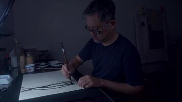 An Asian Artist Creating Ink Lines in Dimly Lit Studio, Part 2 video