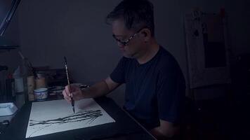 An Asian Artist Creating Ink Lines in Dimly Lit Studio, Part 3 video