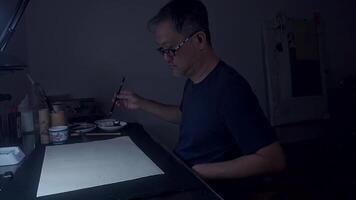 An Asian Artist Creating Ink Lines in Dimly Lit Studio, Part 1 video