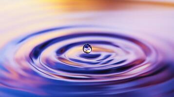 A single water droplet creates concentric ripples in a pool of vibrant, colorful liquid. photo