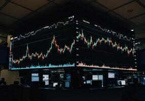 View of a bustling trading floor displaying live stock market data on large screens. photo