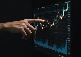 A pointing finger indicates key data on a stock chart, analyzing financial markets. photo