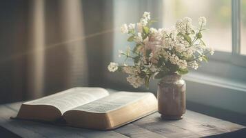 Open bible on the wood table and a bouquet of flowers in a vase next to, christian concept, morning photo