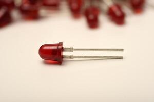 LED bulb. A red LED on the background of a pile of LED elements. One LED. photo
