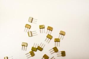 Timeworn transistors on a white platform. Circuitry parts. photo