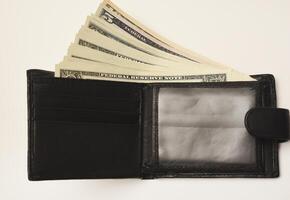 A matte-black wallet with crisp dollar bills on a clean white backdrop. photo