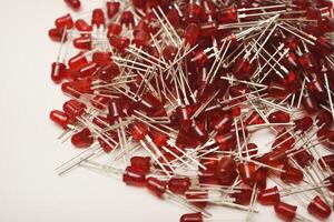 Ruby-hued LED diodes arranged against a stark white backdrop. The wireless module serves as an LED illumination device. photo