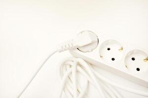 A three-plug electrical strip with a white cord showcased on an ivory-toned background. photo