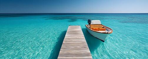 Clear turquoise waters with a boat docked by a wooden pier in calm weather. photo