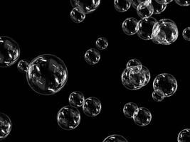 Soap bubbles scattered in the air with a dark backdrop. photo