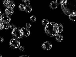 A variety of soap bubbles with reflections on a dark background. photo