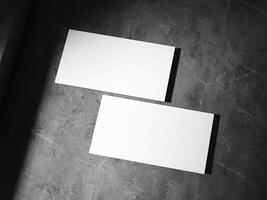 A clean business card placed on a textured stone surface, featuring sharp, well-defined shadows, perfect for a sophisticated brand look. photo