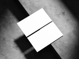 A business card design with sleek white space on a textured dark stone backdrop, offering a modern and professional mockup for brand representation. photo