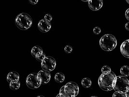 Bubbles with reflections floating in the air on a black background. photo