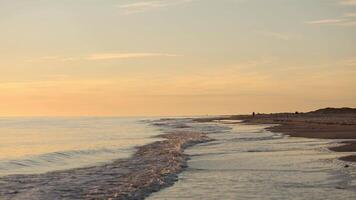 Serene sunset view at a tranquil beach with gentle waves rolling in during the evening hours video