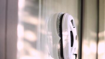 Side view of window cleaning robot on glass with light shadows. video