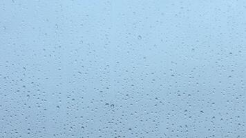 Raindrops accumulate on a window pane as clouds overcast the sky during a rainy afternoon video