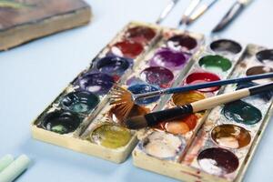 An assortment of paint brushes and paint in a box photo