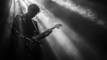 Musician playing guitar on stage, deep shadows and intense lighting photo