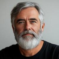 Senior man with gray beard, portrait shot on light grey background photo